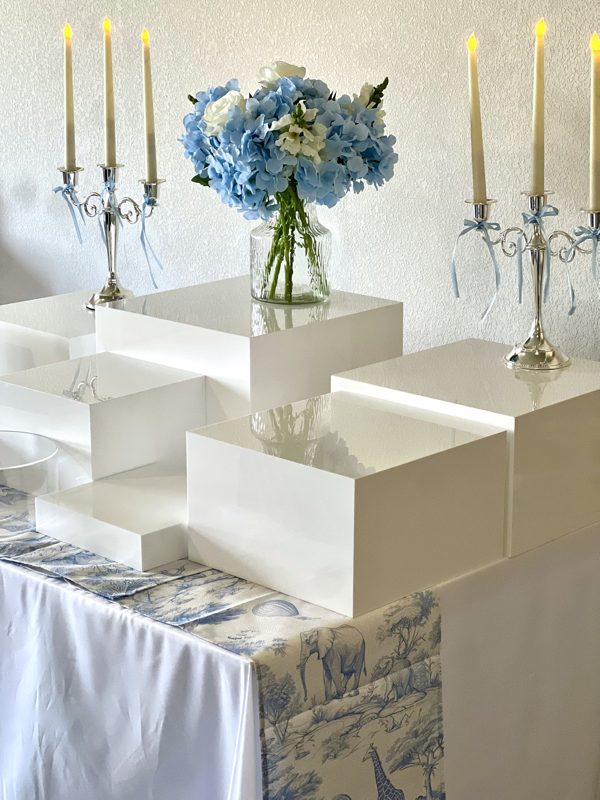 Cubes blanc laqué avec hortensias bleus, chandeliers argentés et chemin de table toile de Jouy
